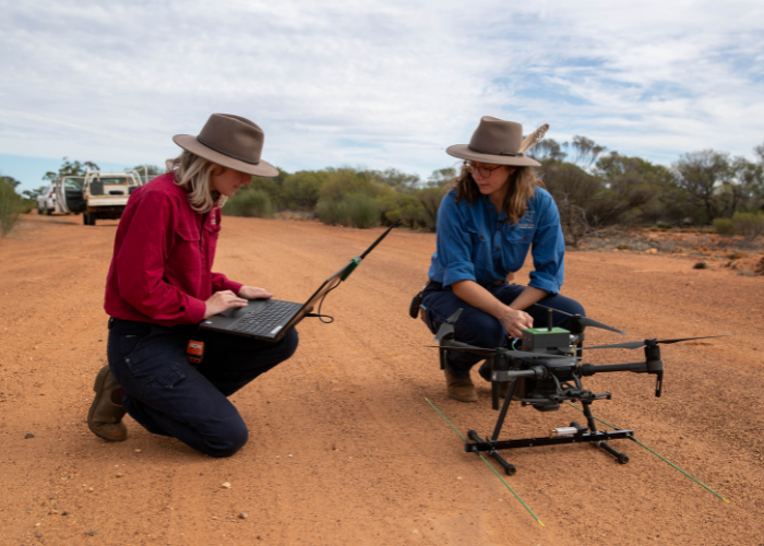 Phoebe Dickins (left) and Georgina Anderson (right), AWC ecologists, prepare to launch a a drone specially-equipped with an advanced radio-telemetry system by Wildlife Drones.